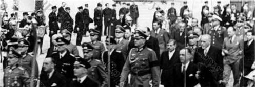 Le Général von Stülpnagel (Militärbefelshaber en France), Fernand de Brinon (ambassadeur en France), suivi de Pierre Laval, et l'ambassadeur Scapini (à l'extrême droite) accompagné de son guide, font leur entrée au Grand Palais.